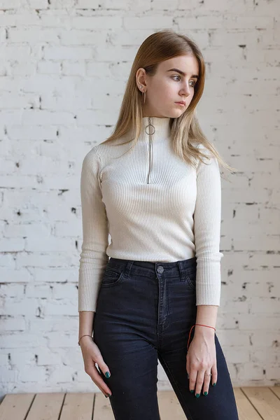 Retrato de jovem modelo adolescente pensativo vestindo suéter branco e jeans pretos — Fotografia de Stock