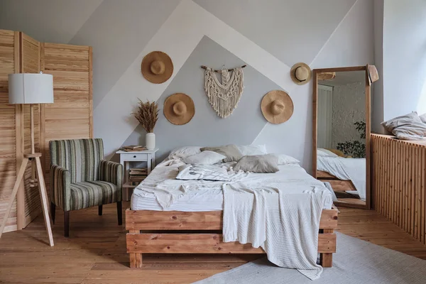 Стильная уютная гостиная с двуспальной кроватью, кресло, ночная лампа, ковер, зеркало — стоковое фото
