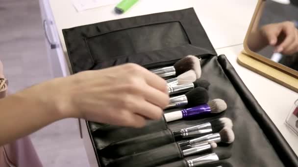 Closeup on makeup artist hand taking brush from professional set at beauty salon — Stock Video