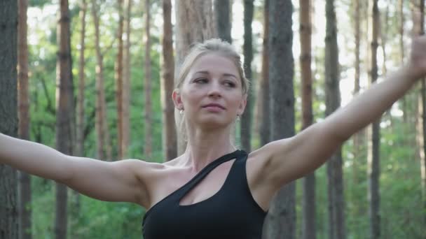 Joven caucásico flexible delgado hembra practicas yoga se mueve en soleado pinar bosque — Vídeos de Stock