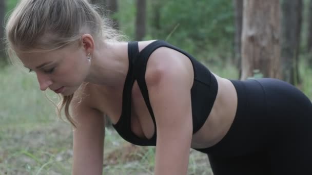 Flexibele slanke vrouwelijke praktijken yoga, voert rajakapotasana in dennenbos — Stockvideo