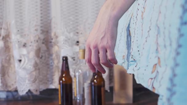 Mans hand hanging from the bed. Empty bottles in the background — Vídeo de stock