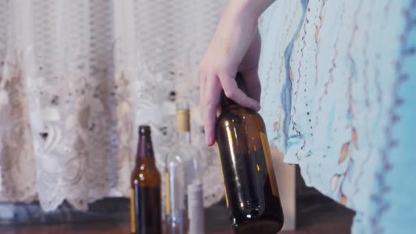 Mans hand drops an empty bottle — Vídeos de Stock