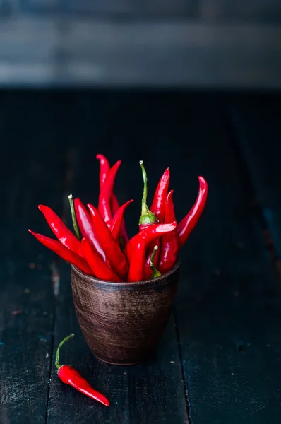 Strauß roter Chilischoten in alter Tasse — Stockfoto