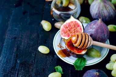 incir ve ahşap masa arka plan üzerinde bal.