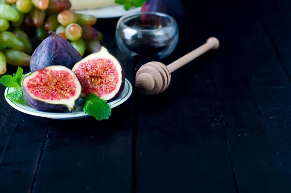 Uva e figos com no fundo de mesa de madeira . — Fotografia de Stock