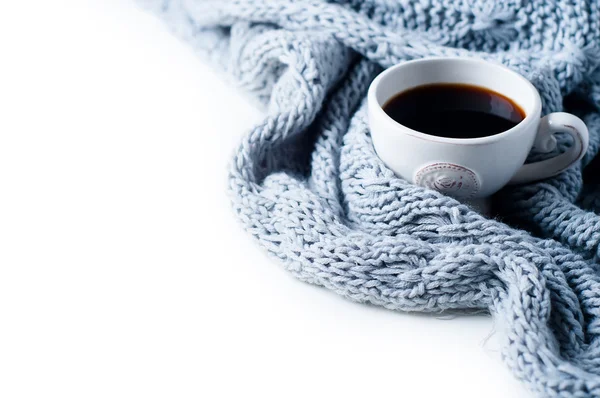 Šálek kávy a pletený svetr na bílý stůl — Stock fotografie