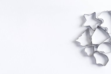 Ev yapımı Noel pastası için metal kurabiye kesicilerden beyaz arka planda, fotokopi alanı. Üst görünüm.