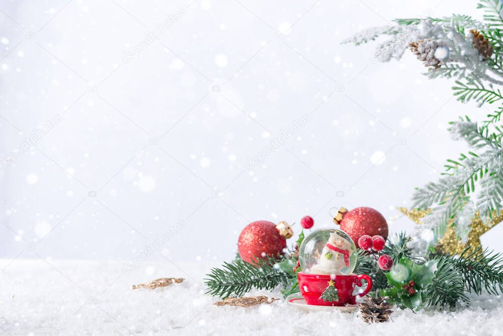 Christmas snow globe with pine branches and festive decorations on snow table. Christmas or New Year concept