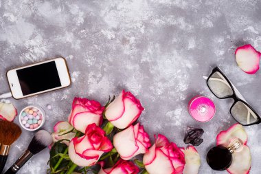 Gül çerçevesi ve dekoratif kozmetik çerçevesi, fotokopi alanı olan bir taş zemin üzerinde. Tarz sahibi kadınlar günü, anneler günü çiçekli arka plan.