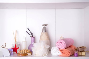 Ahşap tepside havlular aroma çubukları, mumlar, deniz kabukları, masaj bezleri ve içinde şeker kutusu olan bir şişe.