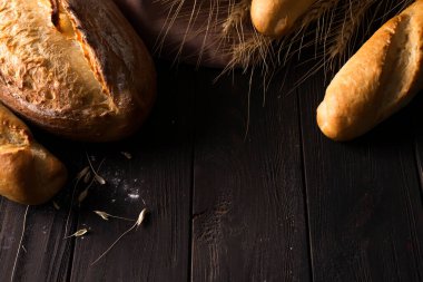 Fırın - siyah arka planda altın kırsal ekmek ve çörekler. Kopya uzayından yakalanan natürmort