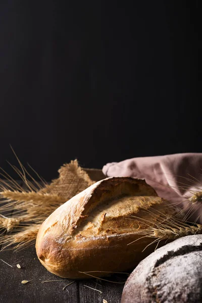 パン屋さん 金パンと黒の背景にパンの素朴な無愛想なパン 上記のコピーの領域キャプチャのある静物 — ストック写真