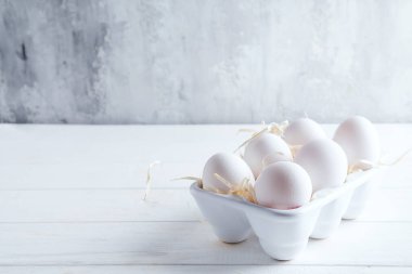 Porselen dekoratif kutuda beyaz organik tavuk yumurtası. Doğal sağlıklı gıda ve organik konsept. Kopyalama alanı ile kapat.