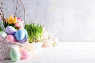 Paskalya sepeti renkli ellerle boyanmış Paskalya yumurtaları hafif bir arkaplan üzerinde, boşluğu kopyala