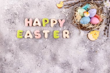 Çimenlik bir yuvada paskalya yumurtaları ve ev yapımı kurabiyeler.