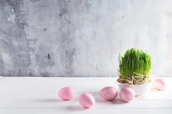 浅色背景下的复活节彩蛋和绿草篮 — 图库照片