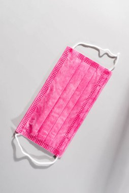 Plastik kulaklıklı cerrahi pembe maske. Bakterilerin prosedür maskesi. Koruma kavramı.
