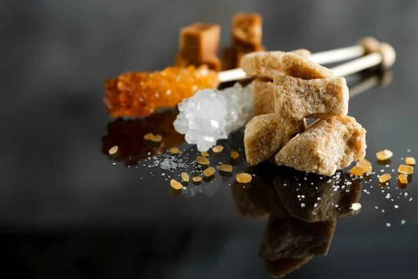 Различные виды сахара - коричневый, белый и рафинированный сахар на черном — стоковое фото