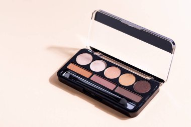 Bej arka planda göz falı, göz farı kozmetik ürünü. Moda blog tasarımı.