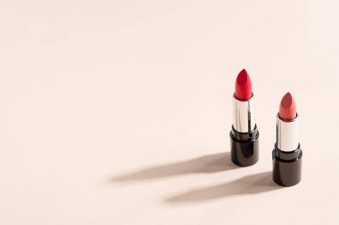 Bej arkaplanda iki kırmızı ruj ve fotokopi alanı. Moda blog tasarımı.