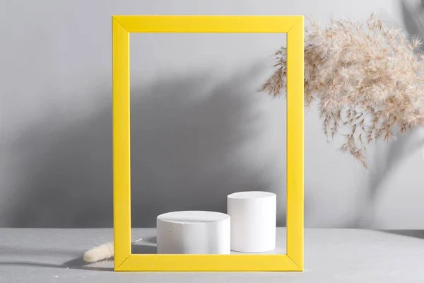 Geometric podium scene with Dry reed and yellow frame on paper ultimate gray background — Stock Photo, Image