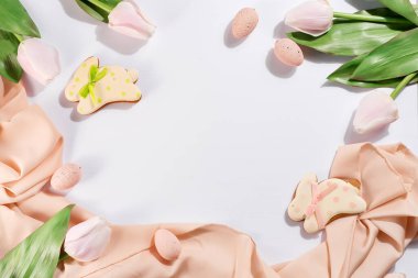 Pastel kumaş ve açık arkaplanda pembe yumurtalı tavşanlı zencefilli kurabiye.