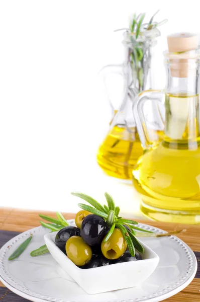 Huile d'olive et branche d'olive sur la table — Photo