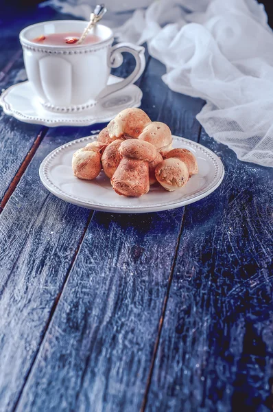 Taza de té con té y galletas en una mesa negra —  Fotos de Stock