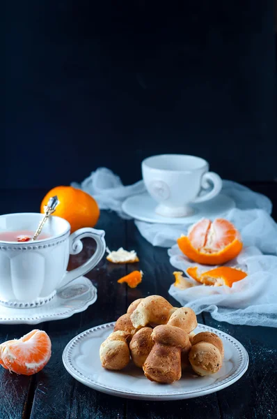 Teacup with tea and biscuits on a black table — Stock Photo, Image