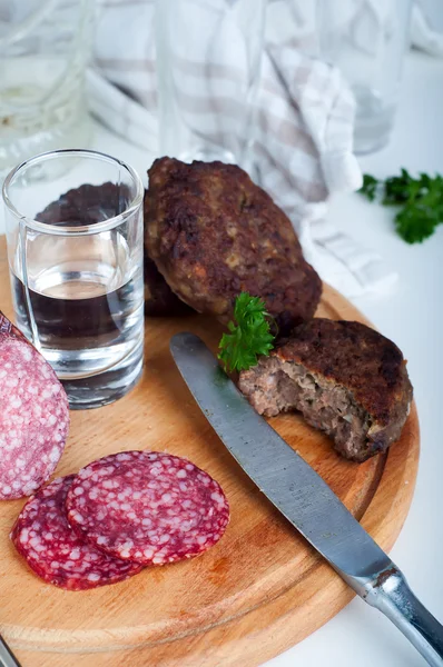 Gläser Wodka und Brettl mit Wurst — Stockfoto