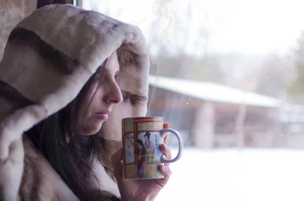 Kobieta, picie herbaty w oknie, obserwując zima zimny dzień znaczenie przez okno - 5 — Zdjęcie stockowe