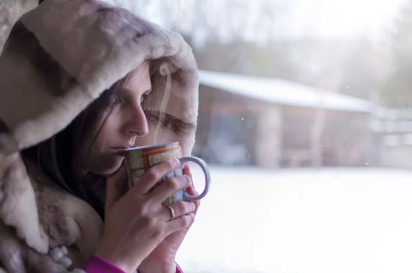 Kobieta pije herbatę w oknie, obserwując czyli dzień zimy przez okno - 3 — Zdjęcie stockowe