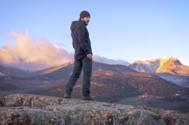 Adam güzel gün doğumu güneşli karlı Mount izlerken üstte