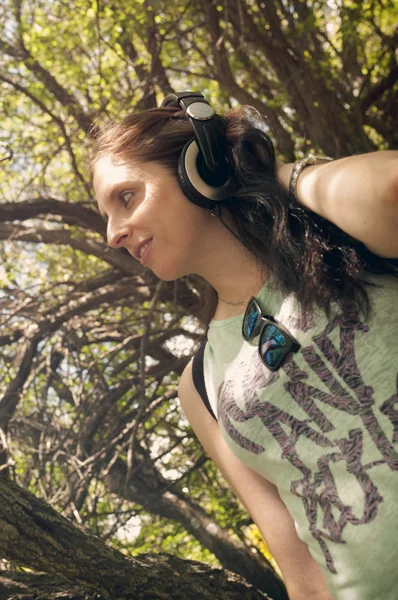 Fiatal nő az erdő zenét hallgat — Stock Fotó