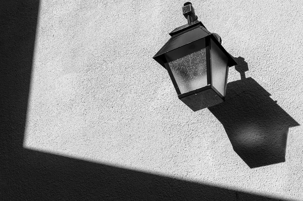 Lamppost on the wall with shadows and textures — Stock Photo, Image