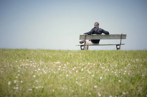 Człowiek siedzący na ławce — Zdjęcie stockowe