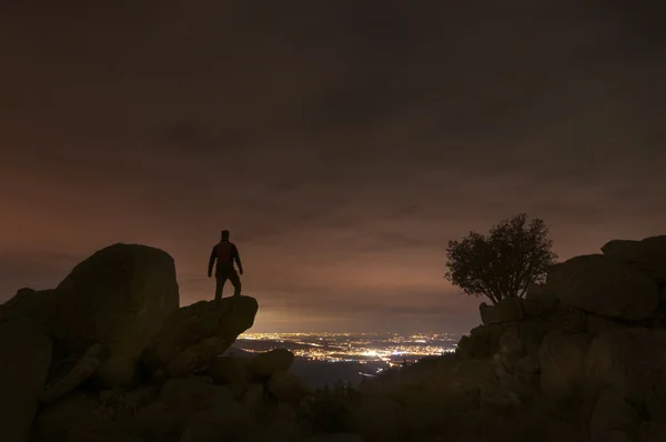 El hombre mira las luces de la ciudad desde la cima de la montaña - 2 — Foto de Stock