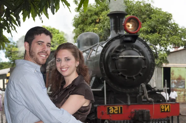 Happy loving couple posing in front of the old train