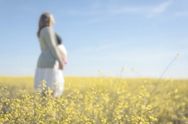 Uvolněné těhotná žena mezi žlutými květy - horizontální — Stock fotografie