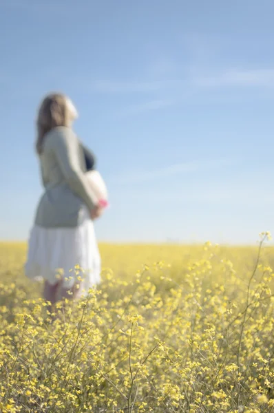 Relaxed pregnant woman among yellow flowers - Vertical — Stock Photo, Image