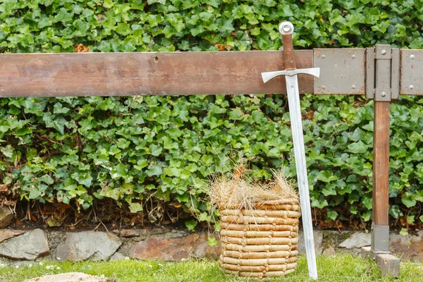 Primer plano de espada medieval y cesta con fondo verde —  Fotos de Stock