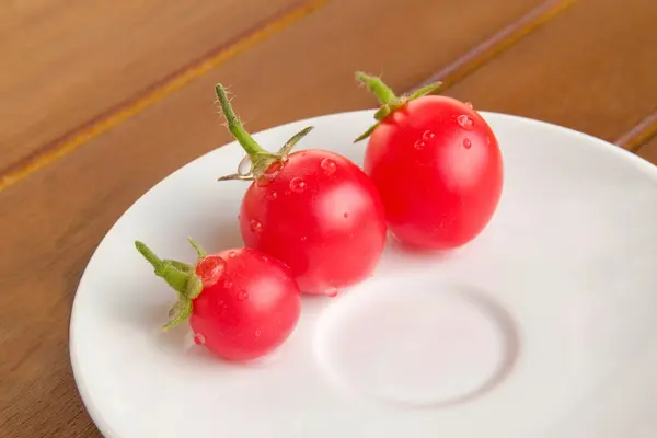 Цветные помидоры на белой тарелке — стоковое фото