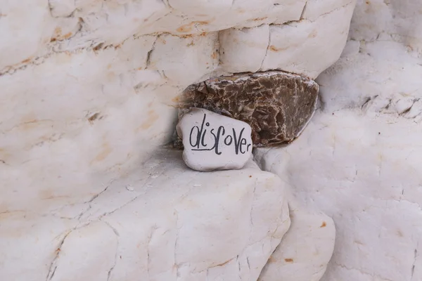 Крупный план красочного пляжного камня со знаком — стоковое фото
