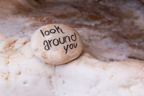 Detailed view of colourful beach stone with sign