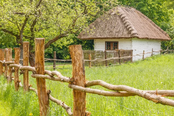 Старый сельский дом с деревянным забором — стоковое фото
