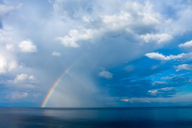 Baykal Gölü üzerinde gökkuşağı ve gökyüzünde yağmur bulutları. Yatay resim.