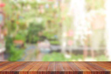 Bahçenin ve evin arka planındaki bulanık yeşilin üzerindeki boş ahşap masa. Montaj ürünü görüntüsü için