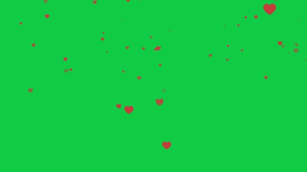 緑の背景に落ちる赤いハートのコンフェッティ 4K映画ビデオ — ストック動画