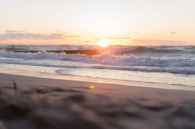 Deniz manzarasında dalgalar var. Denizde gün batımı.